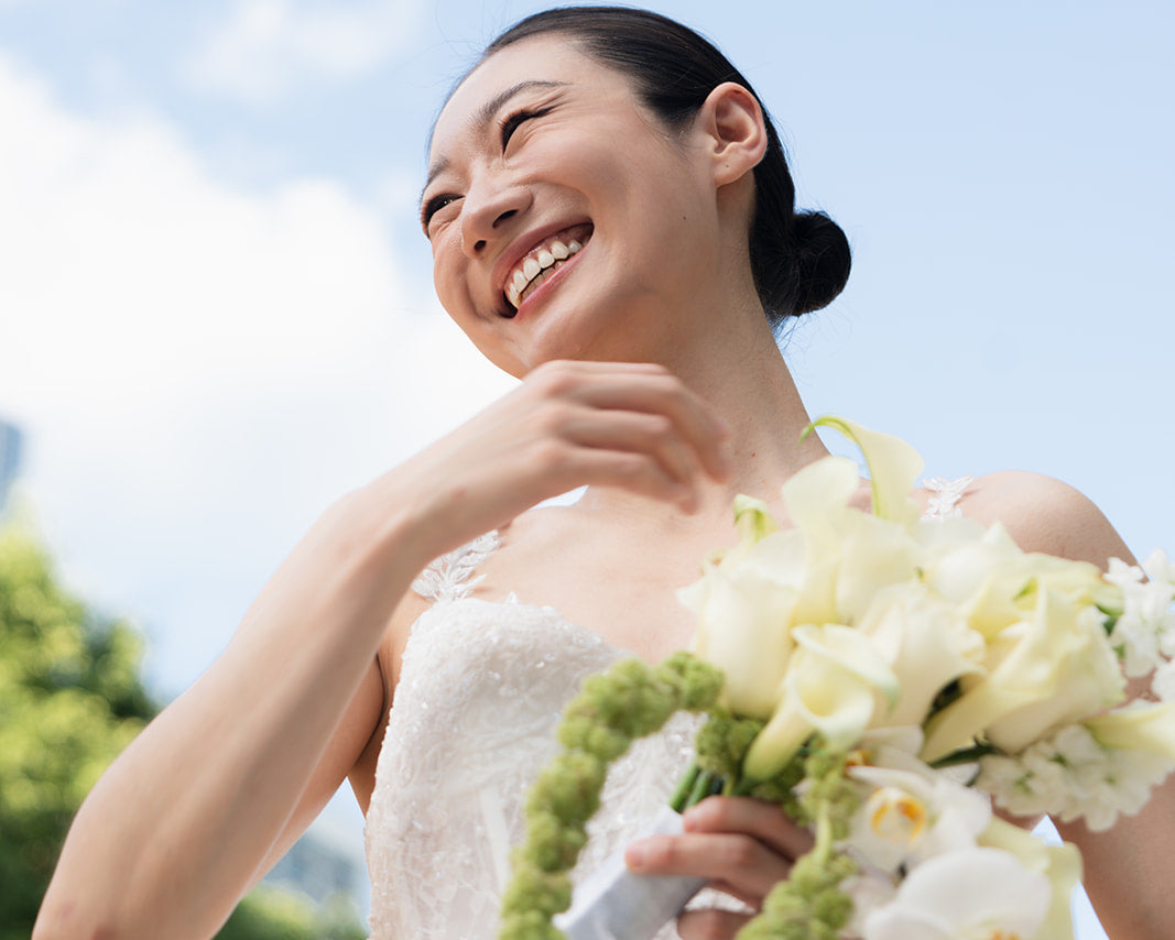 A beautiful bride in a white lace wedding dress holding a bouquet from RF Flowers Chicago